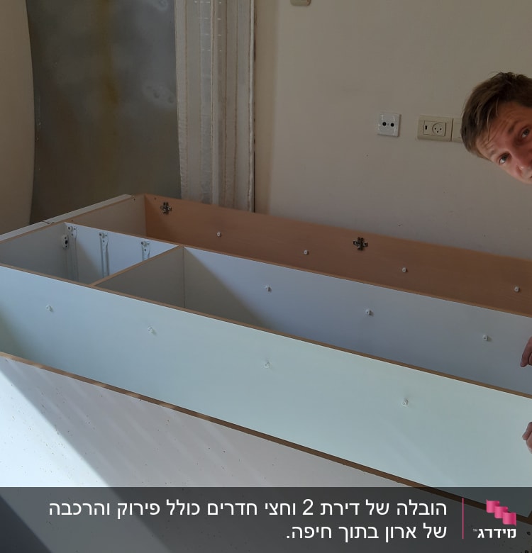 אדם מרכיב רהיט בעזרת מברג בחדר